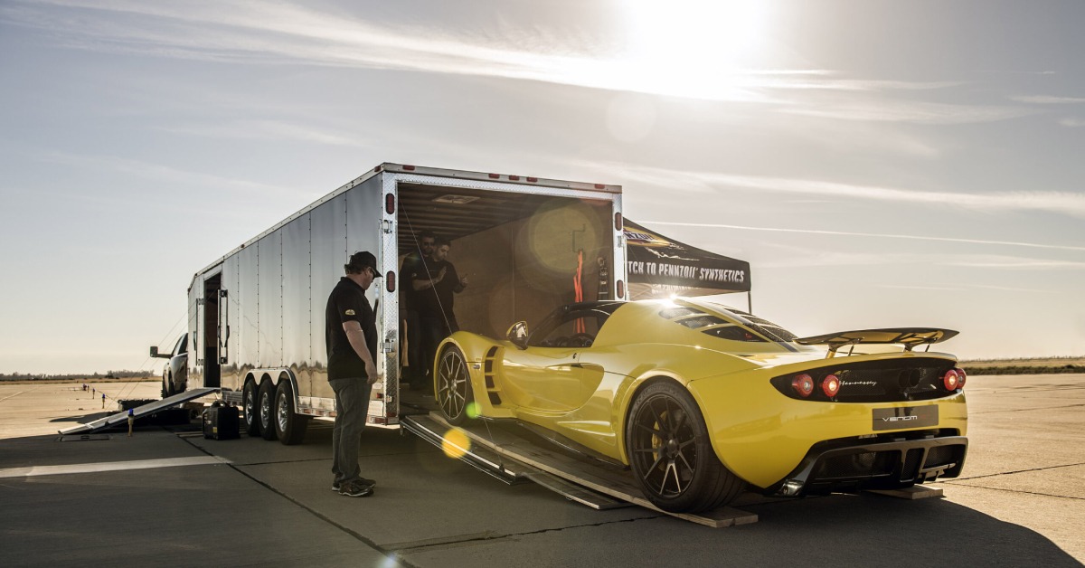 A yellow sports car being loaded onto a trailer